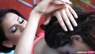 Vanessa Veracruz and Daisy Haze are kissing outdoors