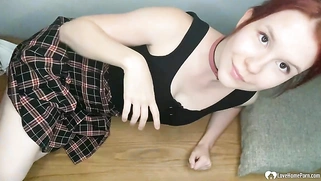 Redhead spreads her legs to finger herself