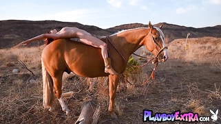 Red babe reveals her pussy on horseback